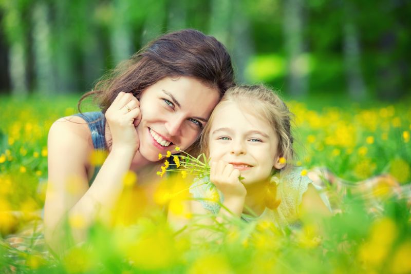 Mother and daughter posing for a photo in a meadow